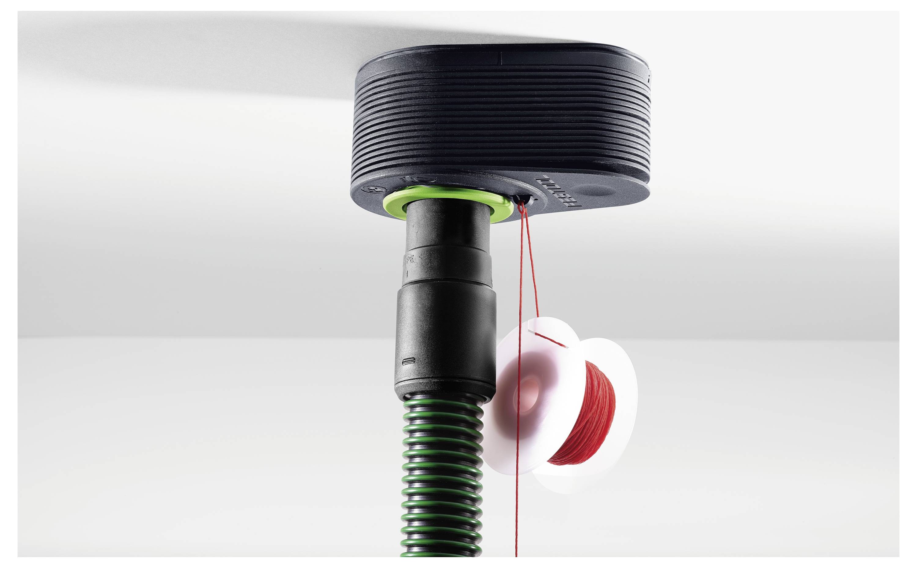 Egy gyomnyírófej behelyezett tekerccsel, amely piros vágóvonalat mutat. A nyírógép fehér háttér előtt van elhelyezve.