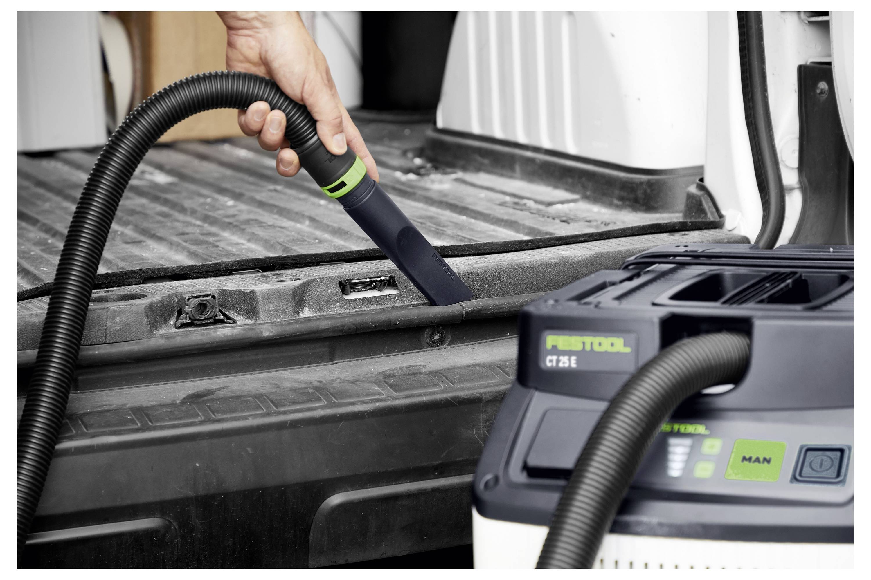 Egy személy elektromos fűrésszel vágja a fát egy asztalon, összpontosítva és biztonsági szemüveget visel, amely a famunkát akcióban ábrázolja.