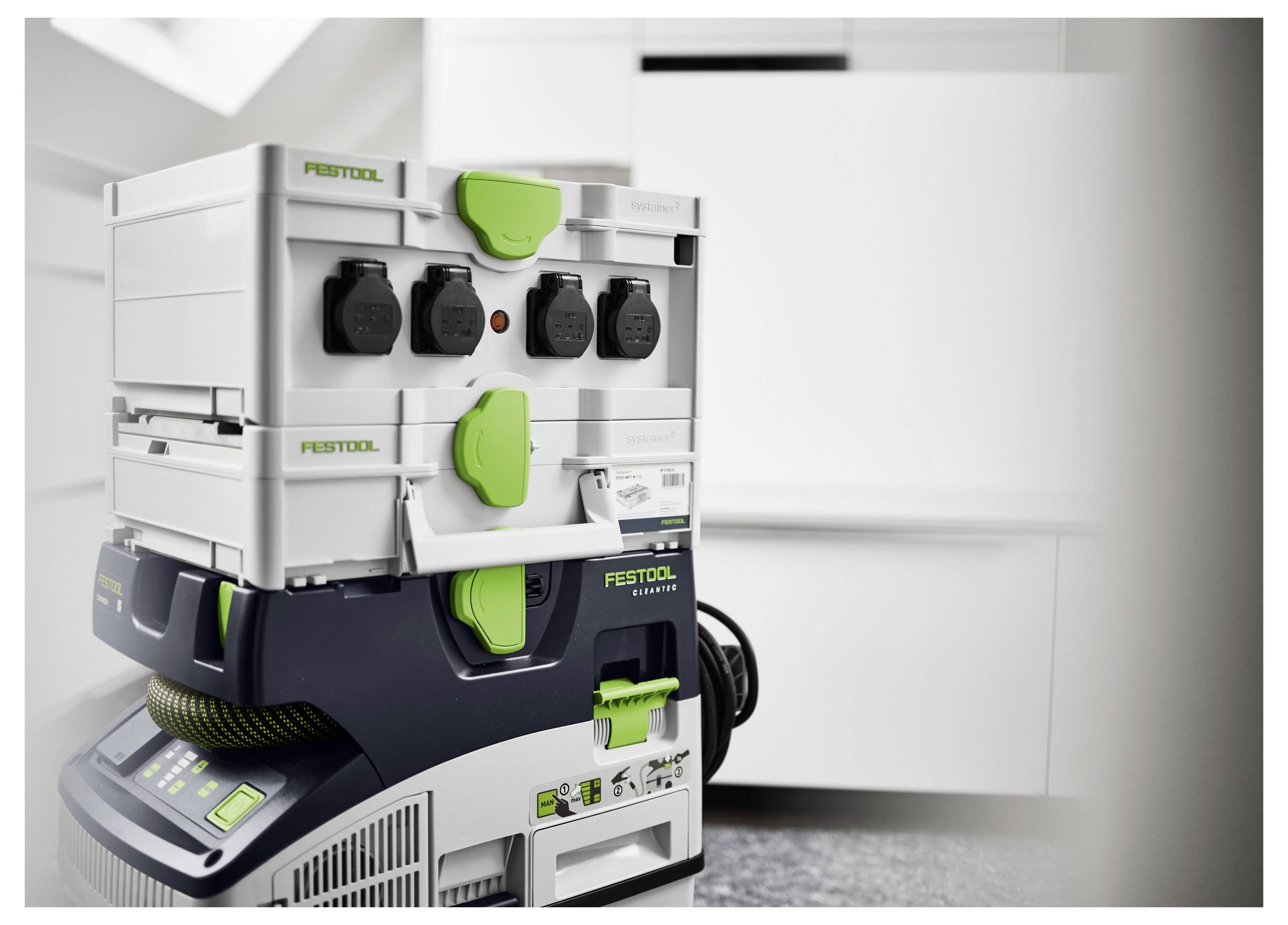 Egy több eszközös töltőállomás szerszámokkal és kábelekkel, fehér és zöld egységben, egy modern, minimál stílusú szoba belsejében.