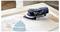 Egy kézi elektromos csiszoló egy fafelületen nyugszik, mellette két háromszög alakú csiszolópapír található, amely a csiszolás folyamatát sugallja.