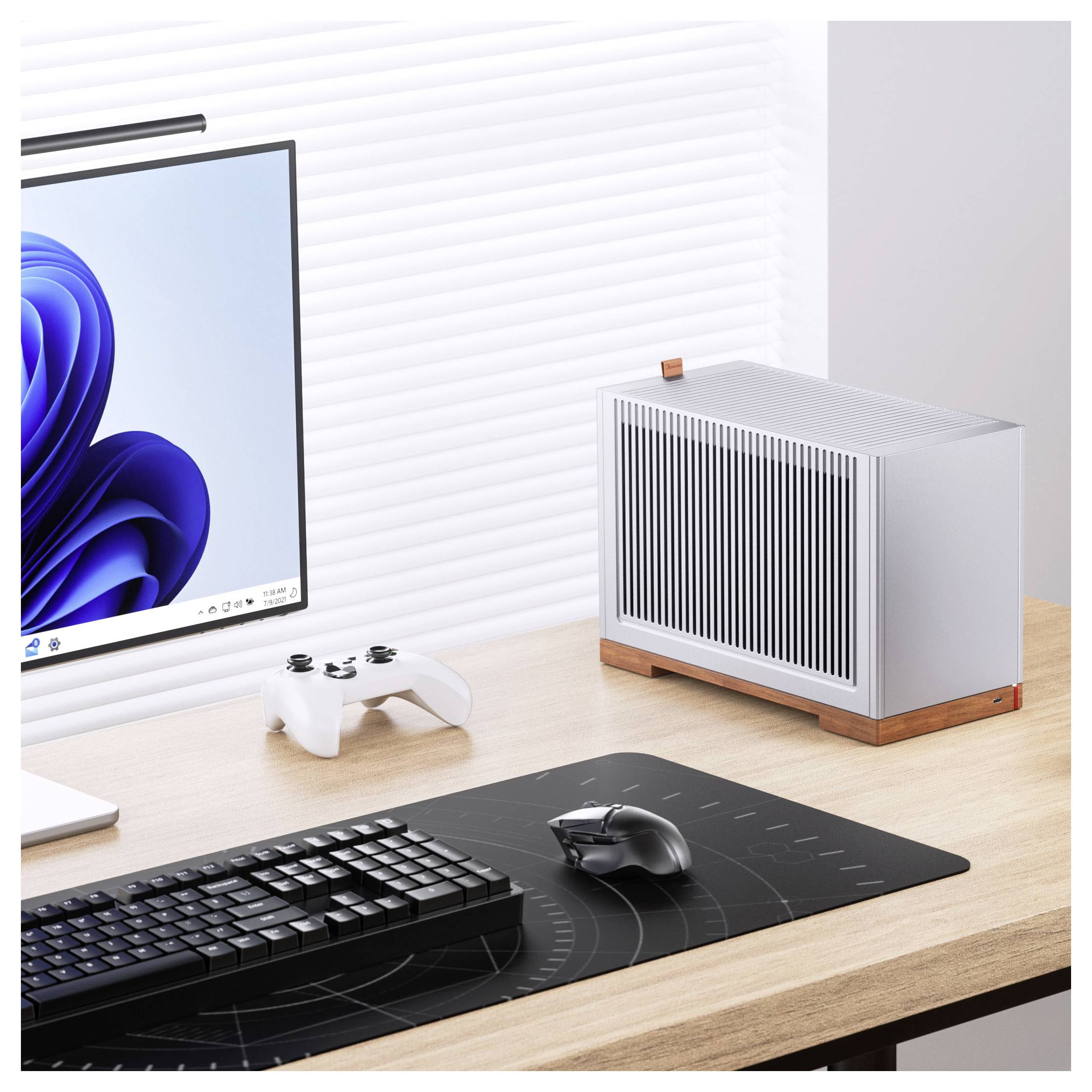Egy modern asztali beállítás, amely egy csinos számítógépes monitort, egy vezetéknélküli billentyűzetet és egeret egy szőnyegen, valamint egy minimalistikus számítógépes házat tartalmaz egy fa asztalon.