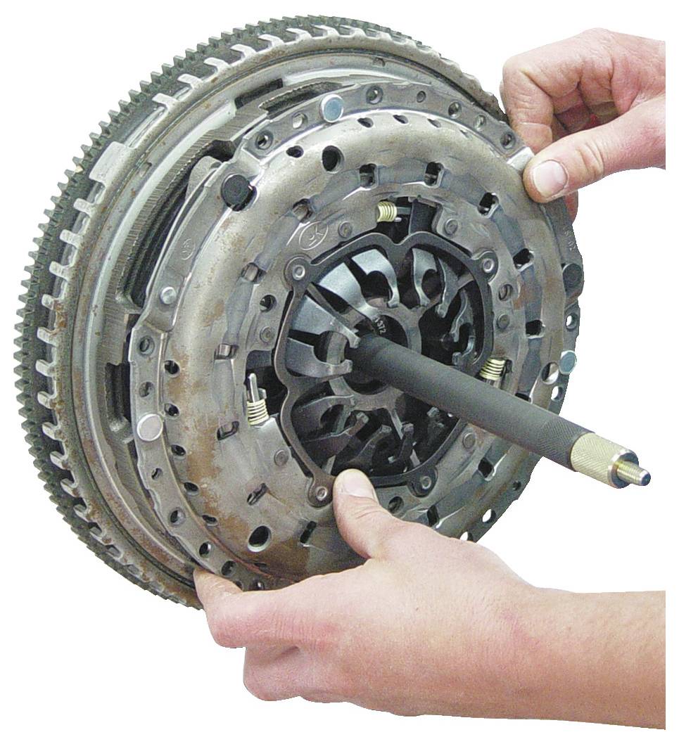 Két kéz egy kuplungsszerelési eszközt tartva, azt a jármű kuplunglemezén belül igazítva a telepítéshez, a részalkalmazást fókuszba helyezve.