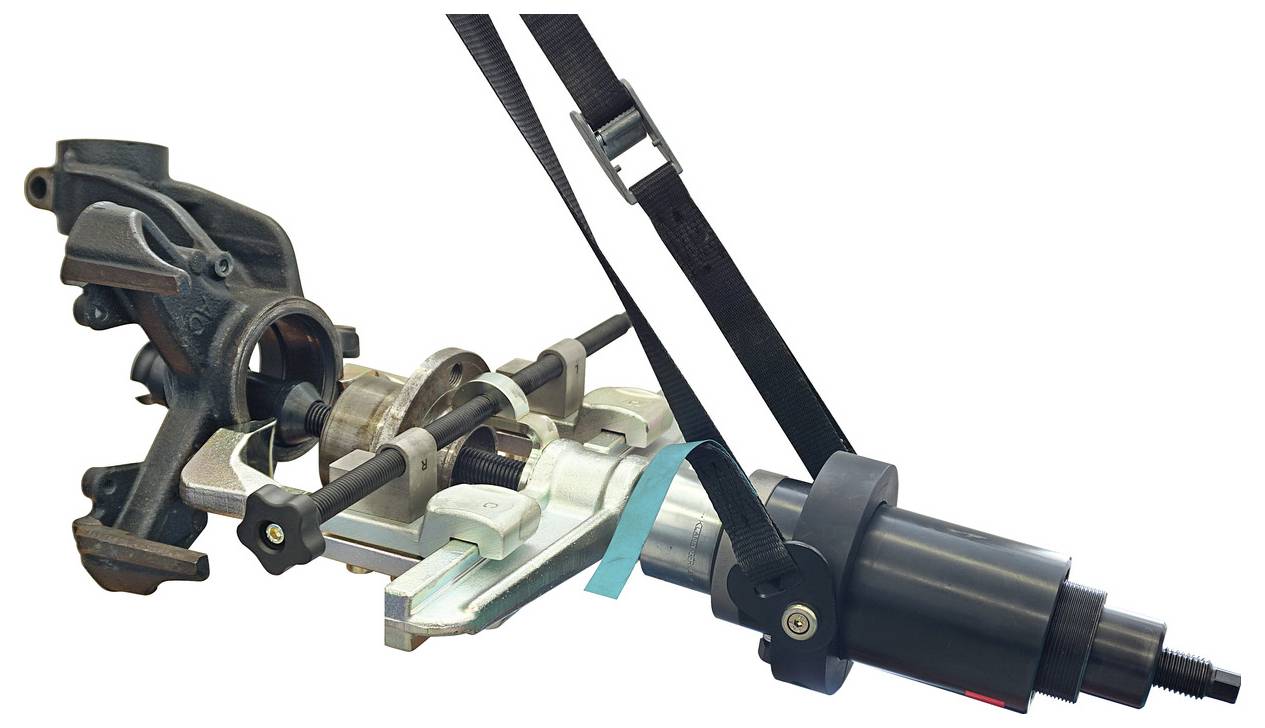 'Az kerékcsapágy kormányzási löketre történő eltávolítására szolgáló eszköz látható. Hidraulikus hengert és különféle kiegészítéseket tartalmaz.'