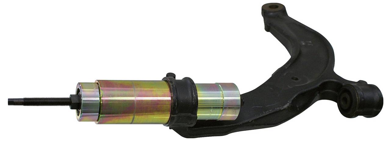 Fekete dugattyúval rendelkező hidraulikus sajtó, kábelekkel összekötve, két függőleges rúddal és fém alappal, anyagok tömörítésére használt.