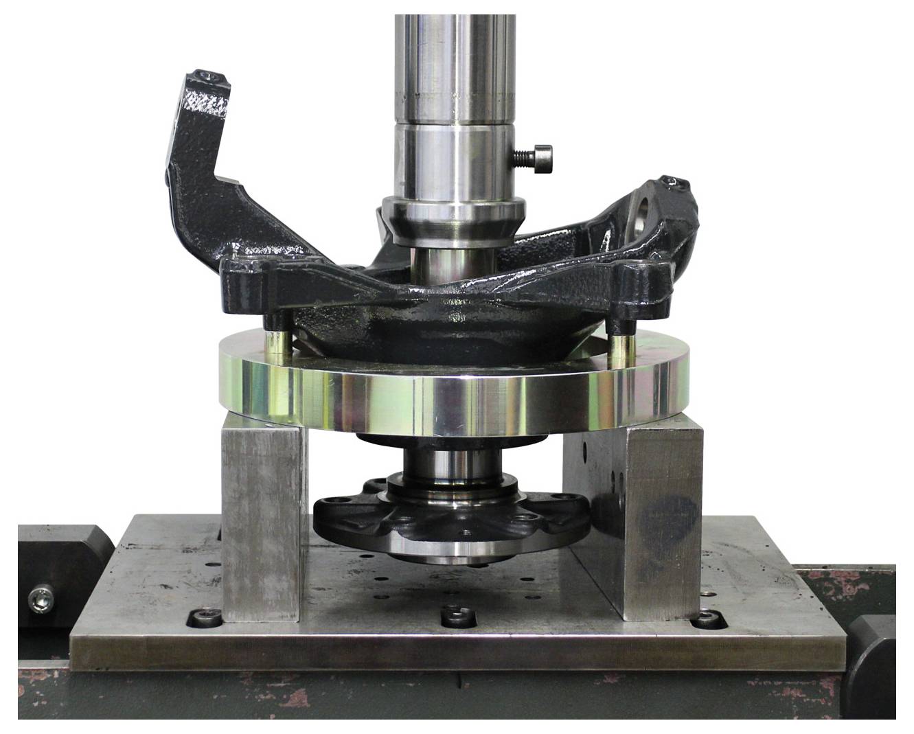 'Egy fémes tárgy, amely szilárdsági tesztelésen megy keresztül egy gépen, bilincsek helyezkednek el körülötte a stabilitás érdekében.'