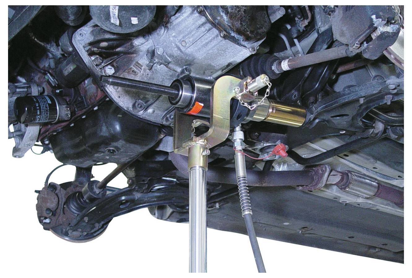 Egy hidraulikus eszköz egy gömbcsukló eltávolítására a járműváz felfüggesztéséből, amely a mechanikus alkatrészeket és csatlakozásokat mutatja.