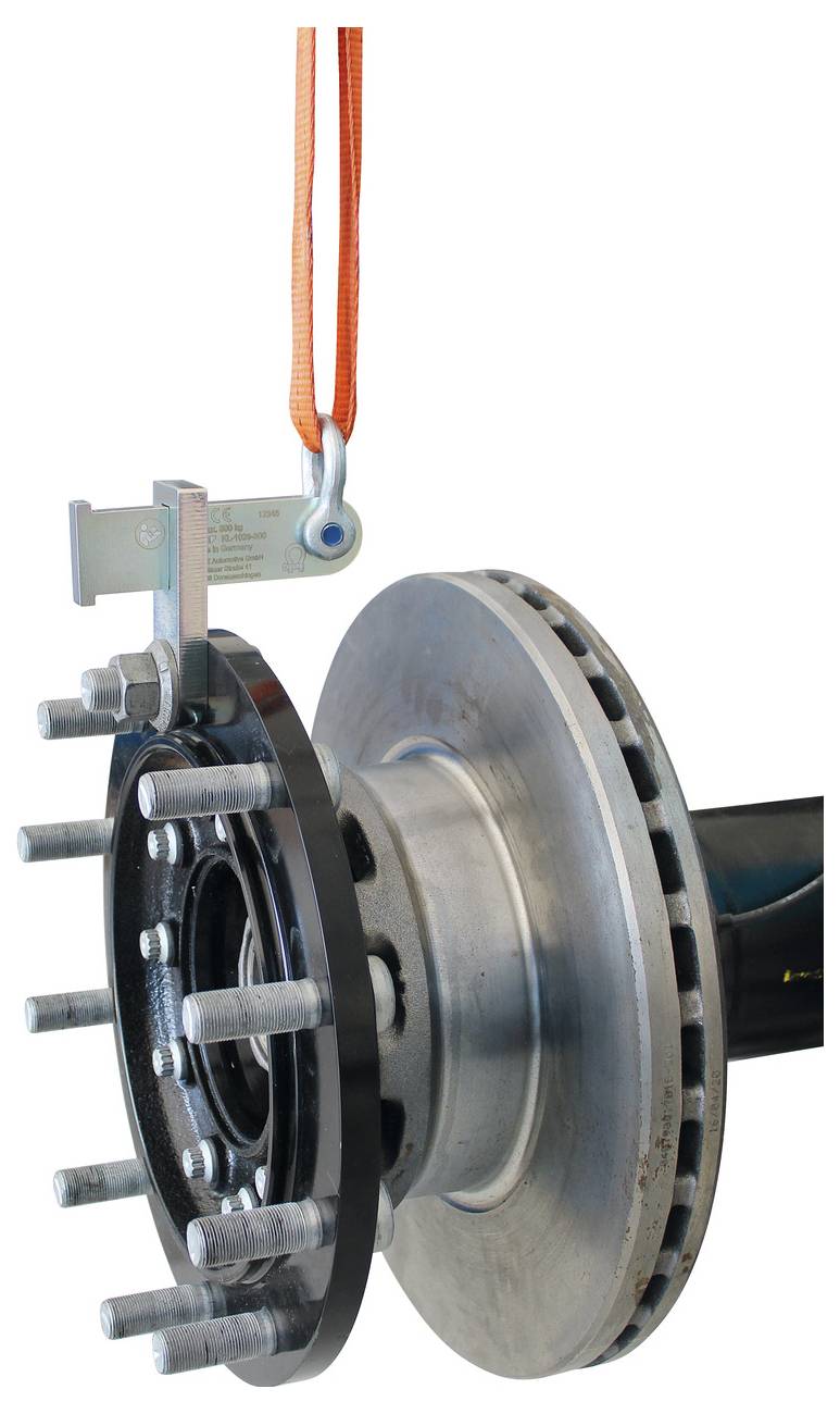 A féktárcsa és kerékagy-szerelés egy narancsszínű szalag által felfüggesztve van, bemutatva az alkatrészek csatlakoztatását és szerkezeti kialakítását.