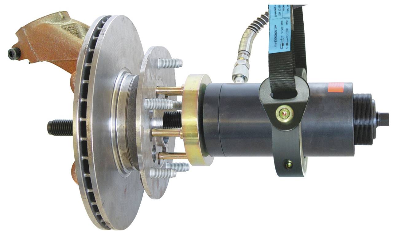 Egy gépegység közeli felvétele, amely egy féktárcsát és kerékagy-szereletet mutat, amely egy szerszámhoz vagy készülékhez csatlakozik.