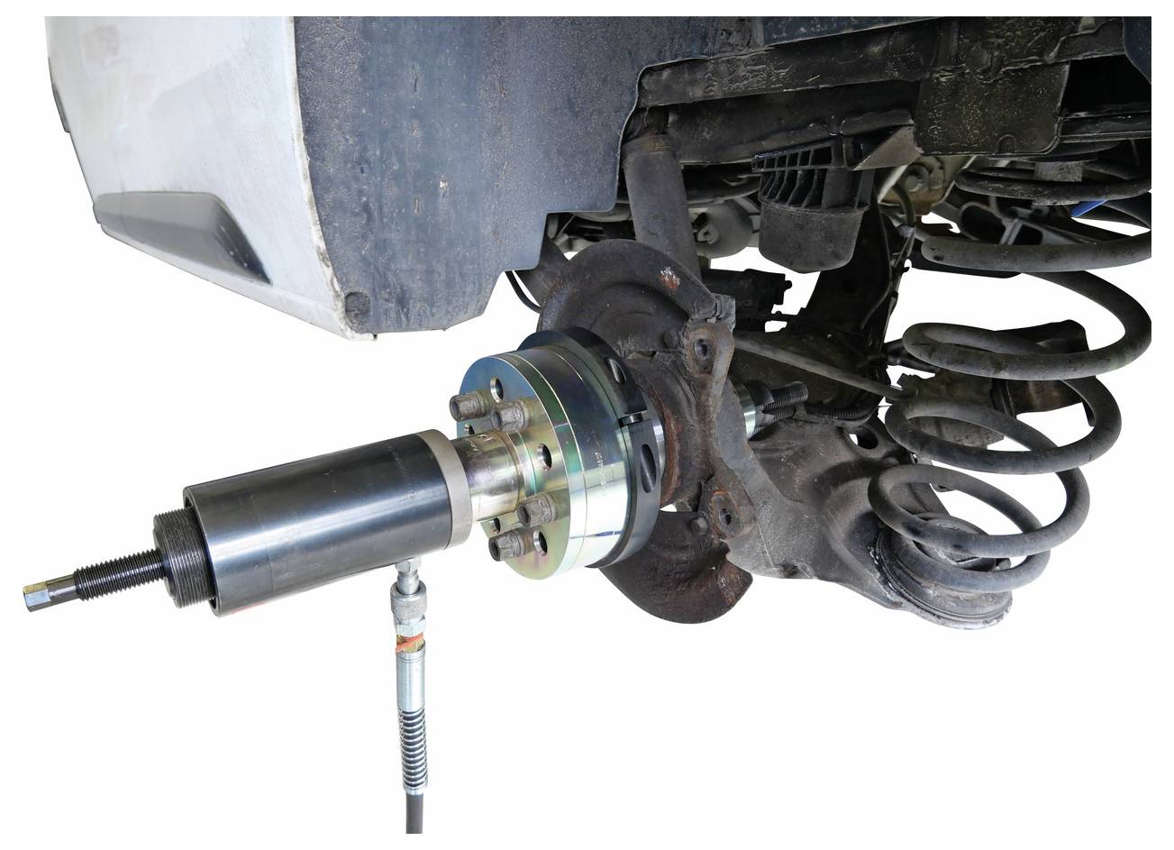 Egy hidraulikus szerszám egy autó felfüggesztési rendszeréhez csatlakoztatva, amely a kerékagyag vagy csapágy cseréjének vagy karbantartásának folyamatát mutatja be.