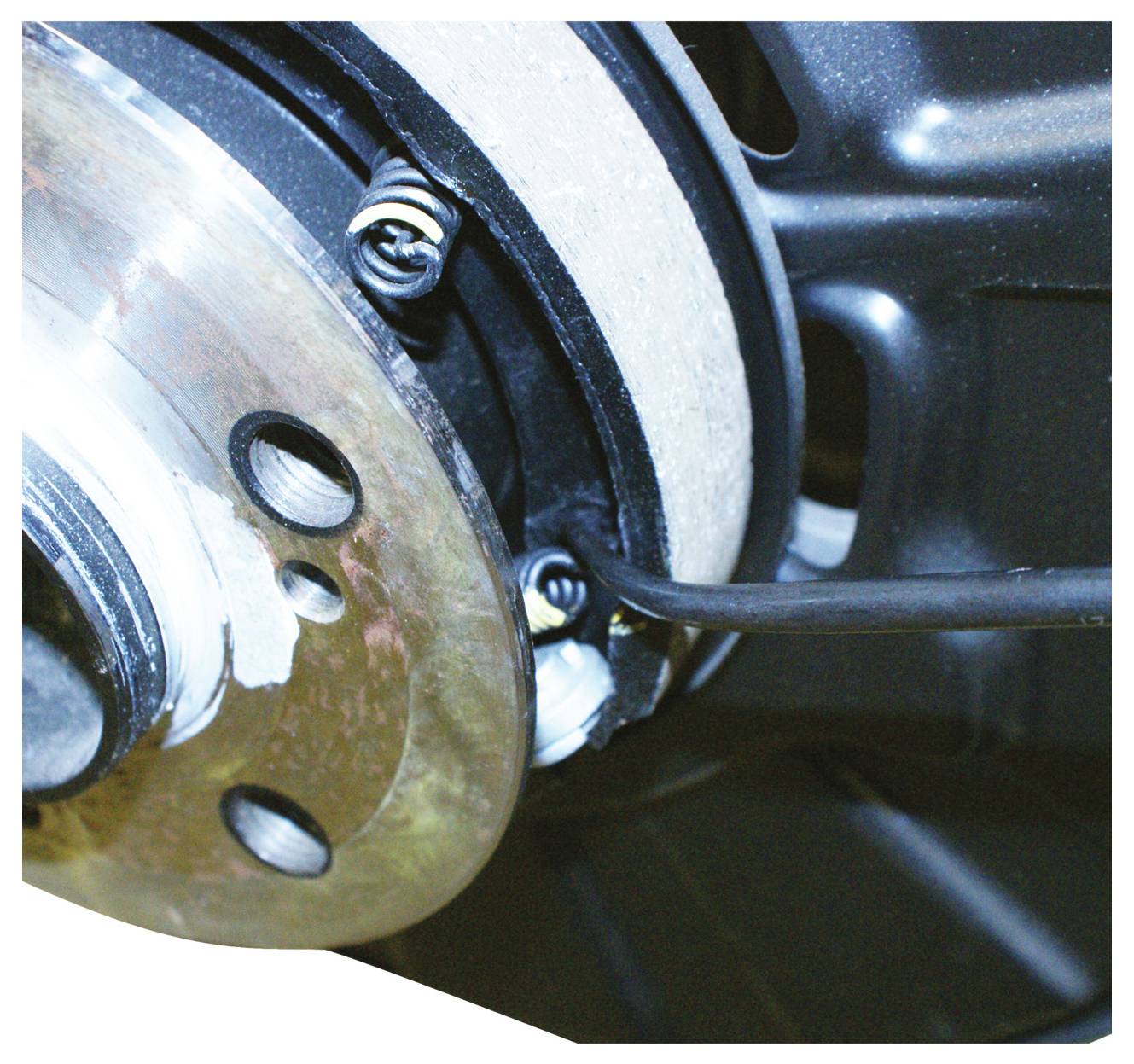 Egy féktárcsás fékrendszer részletközelről, amely féktárcsákat, fékbetéteket és féknyerget mutat.