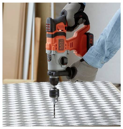 Egy kesztyűt viselő személy egy akumulátoros fúró-csavarbehajtót használ egy kockás fémlap munkálataihoz.