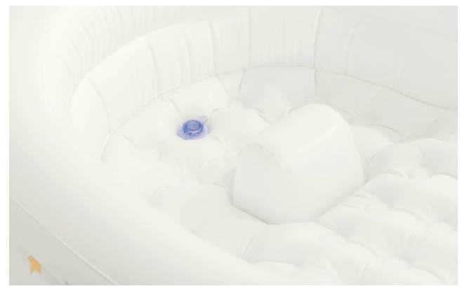 Egy felfújható fehér kád textúrált alappal és egy kék kör alakú dugóval az alján.