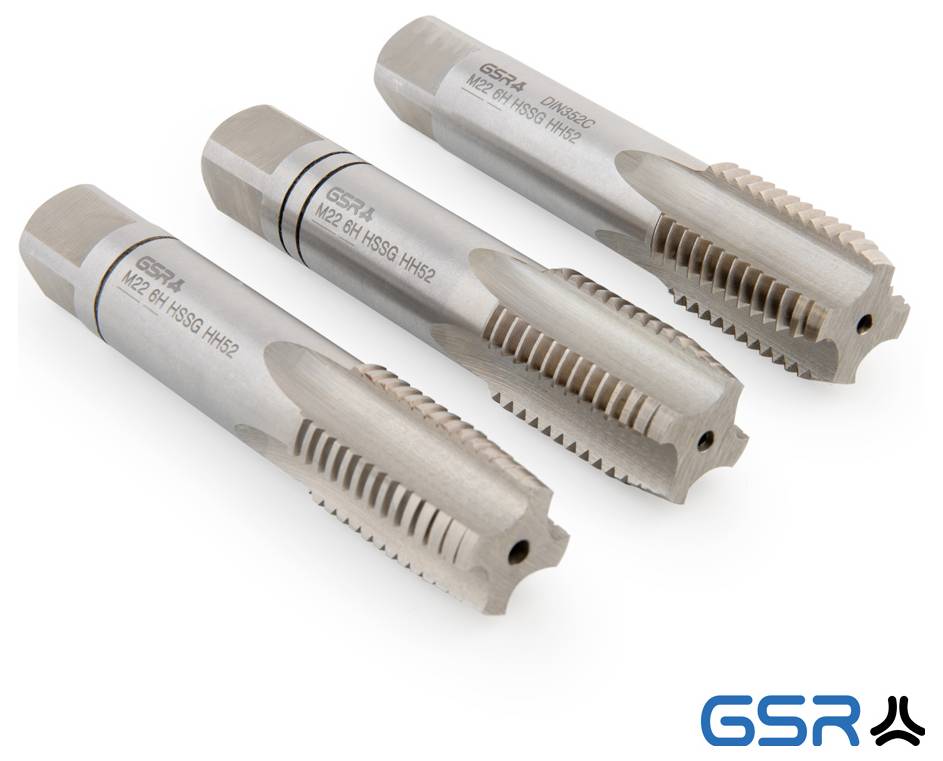 Egy fém csavarmenettel rendelkező szerszám nagyítása, hegyes hegyű, valószínűleg csavarmenetek vágásához használt menetfúró, amely részletes vágóéleket mutat.