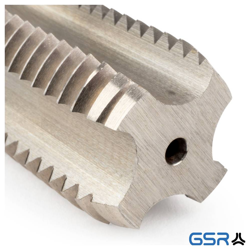 Egy fémes menetemelő szerszám közeli képe éles bordákkal és egy kis lyukkal, amely hengeres nyílások belsejében menetek létrehozásához használatos.