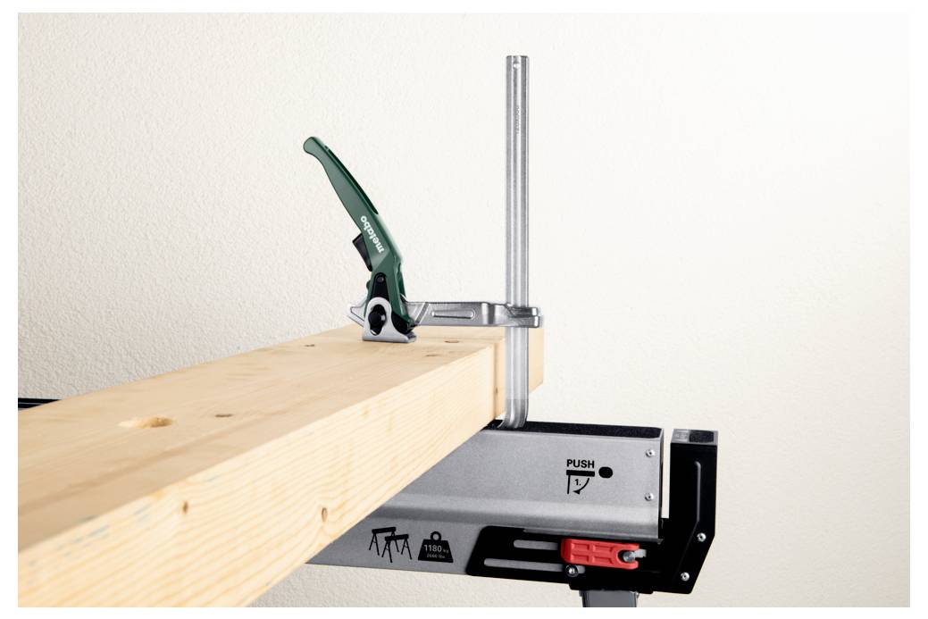 Egy fából készült gerenda biztonságosan befogva egy munkaasztalon, zöld fogantyús szorítóval rögzítve, amely egy stabil setup-ot demonstrál a famunkáláshoz.