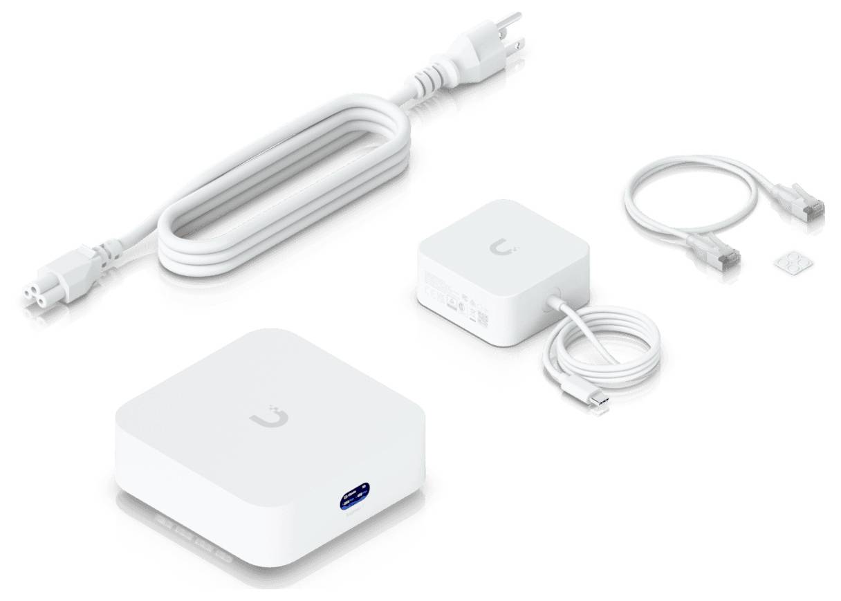 Egy kicsi fehér hálózati eszköz USB-porttal, egy fehér hálózati adapter, Ethernet-kábelek és egy SIM-kártya-tálca egy világos felületen.