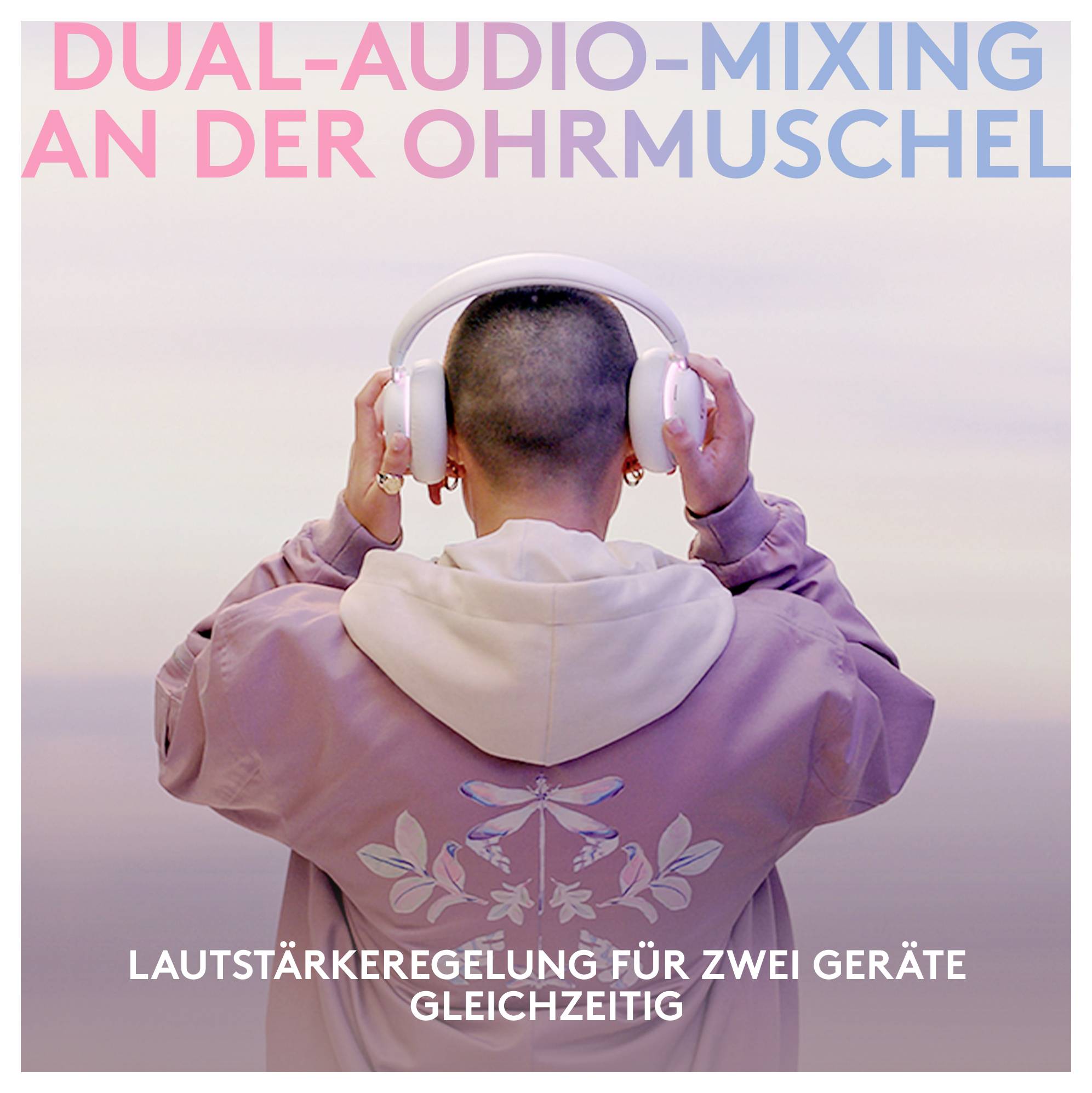 A személy hátulról látható, fehér fejhallgatót és rózsaszín kapucnis pulóvert visel, amelyen német felirat olvasható: „DUAL-AUDIO-MIXING AN DER OHRMUSCHEL" és „LAUTSTÄRKEREGELUNG FÜR ZWEI GERÄTE GLEICHZEITIG".