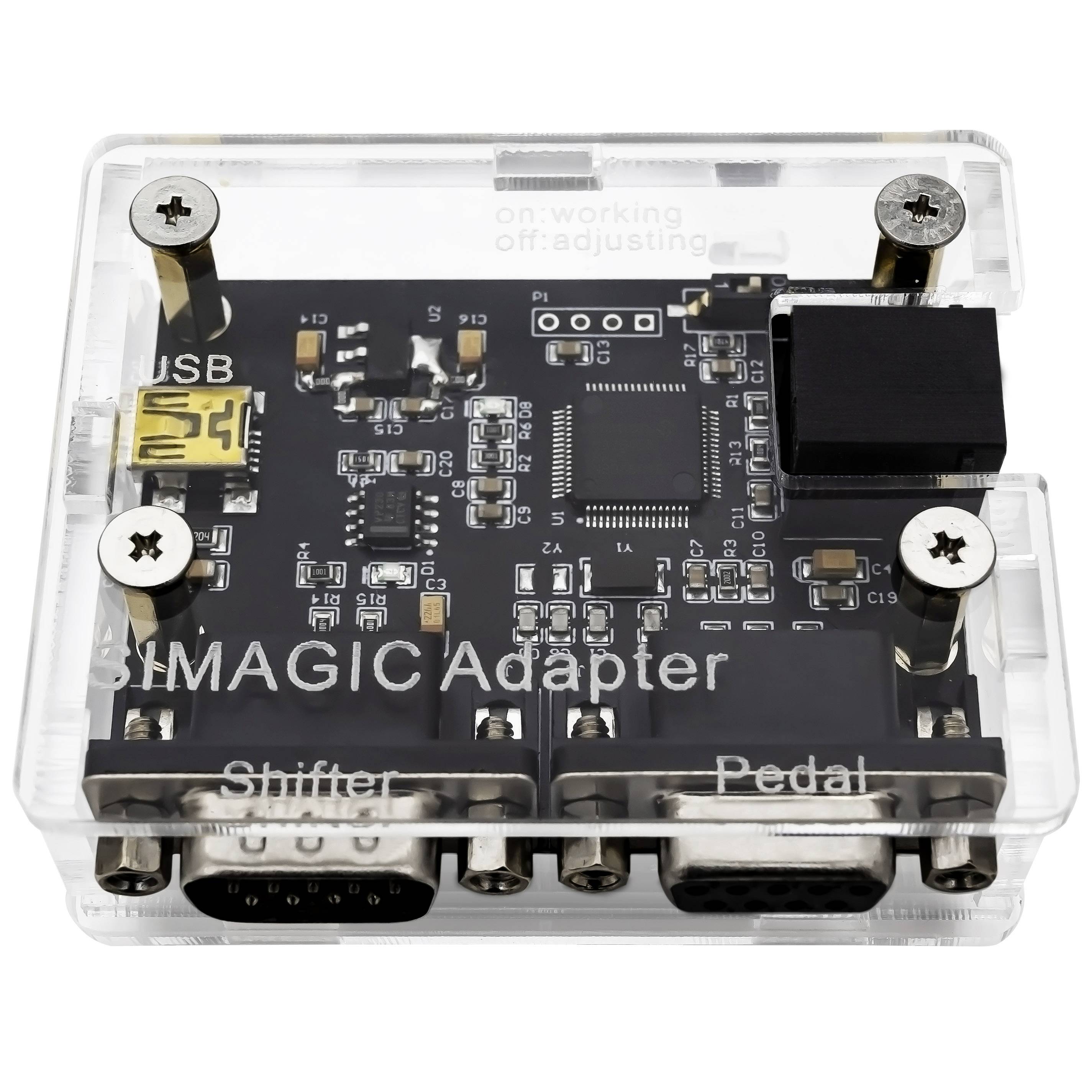 Átlátszó "MIXMAGIC Adapter" elektronikus interfész tábla USB porttal és két alsó csatlakozóval, amelyek "Shifter" és "Pedal" címkékkel vannak ellátva.