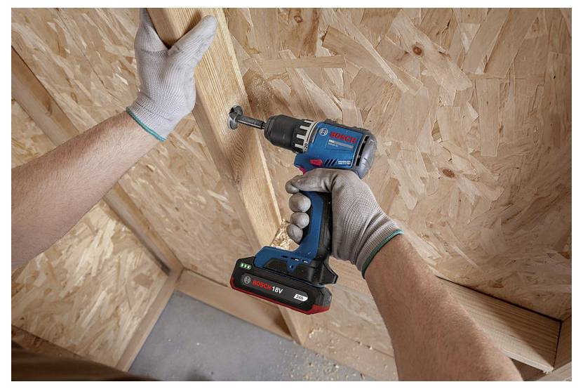 Kezek egy cordless Bosch fúróval egy falapot rögzítenek az OSB-kerettel ellátott szerkezetben.