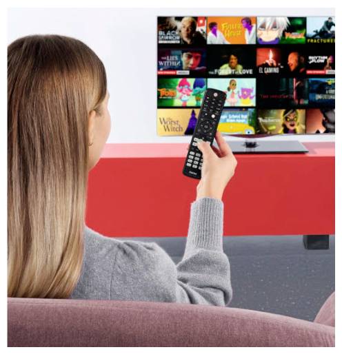 Egy kanapén ülő személy távirányítót használ egy streaming TV menü böngészéséhez, ahol film- és sorozat-miniatűrök jelennek meg a képernyőn.