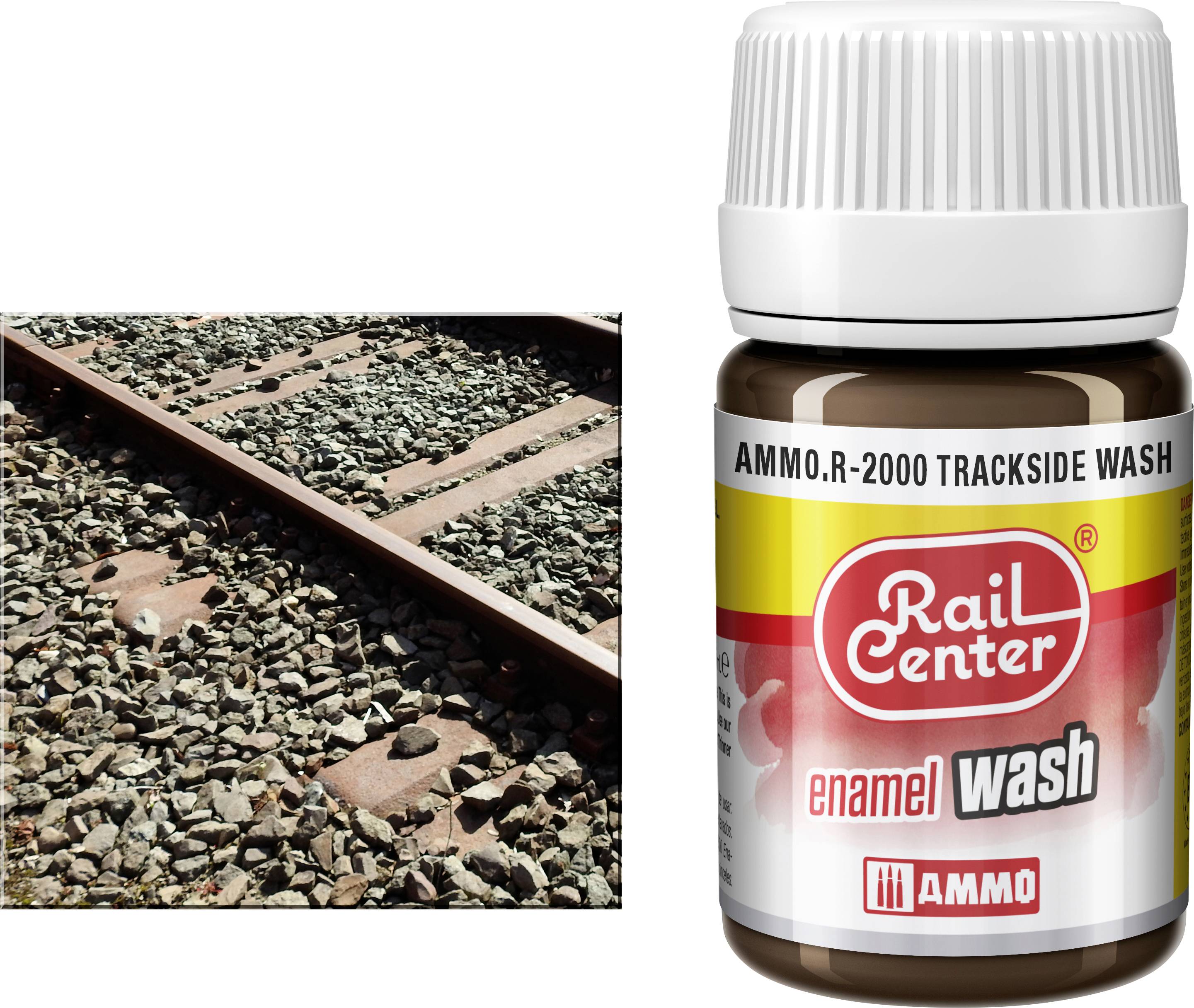 Vasúti pályakavics egy "AMMO.R-2000 TRACKSIDE WASH" feliratú palack mellett és "Rail Center zománc mosás" felirat.