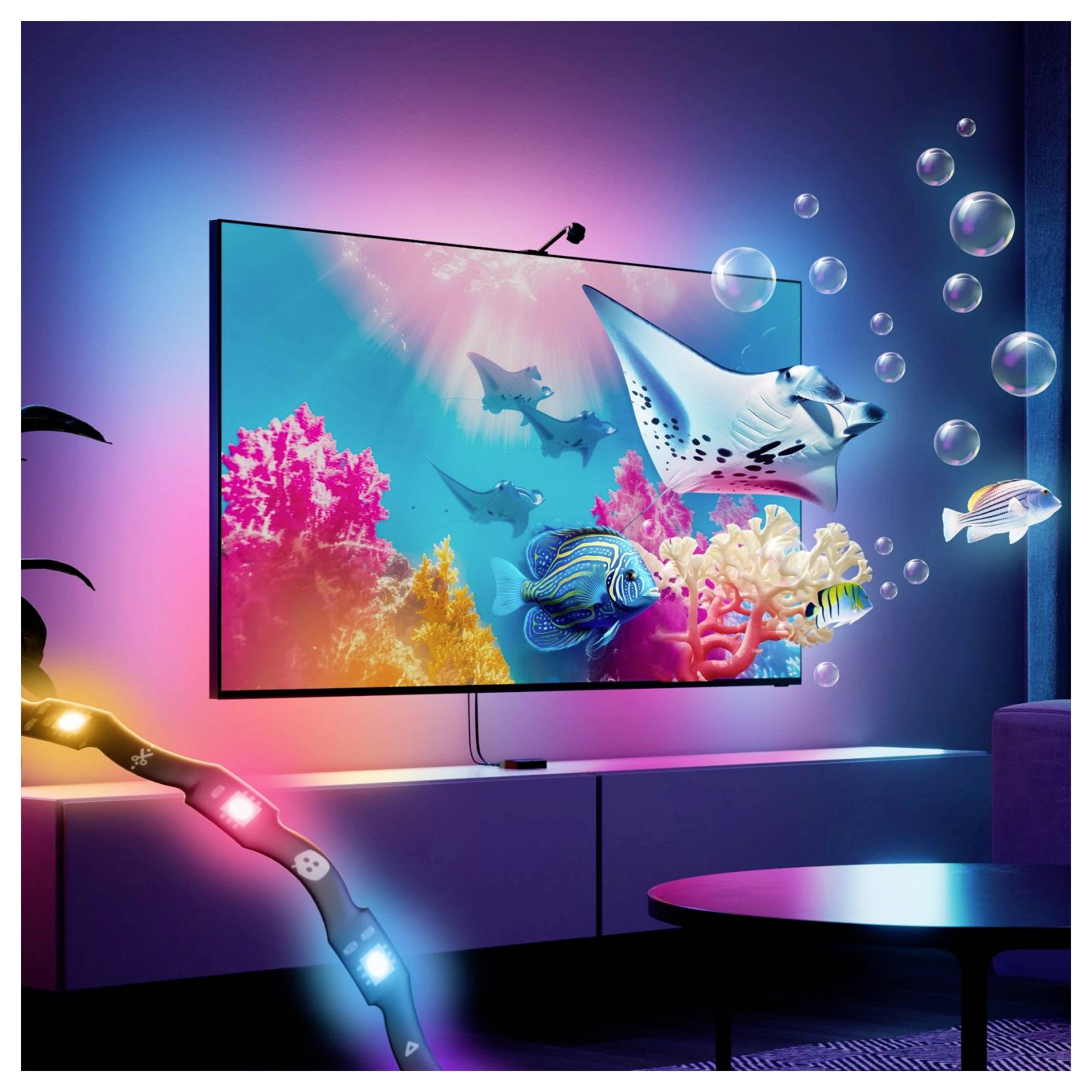 Falra szerelt TV-képernyő élénk színű víz alatti jelenetet mutat korallokkal, halakkal és egy manta sugarassal egy neon-világított modern szobában.
