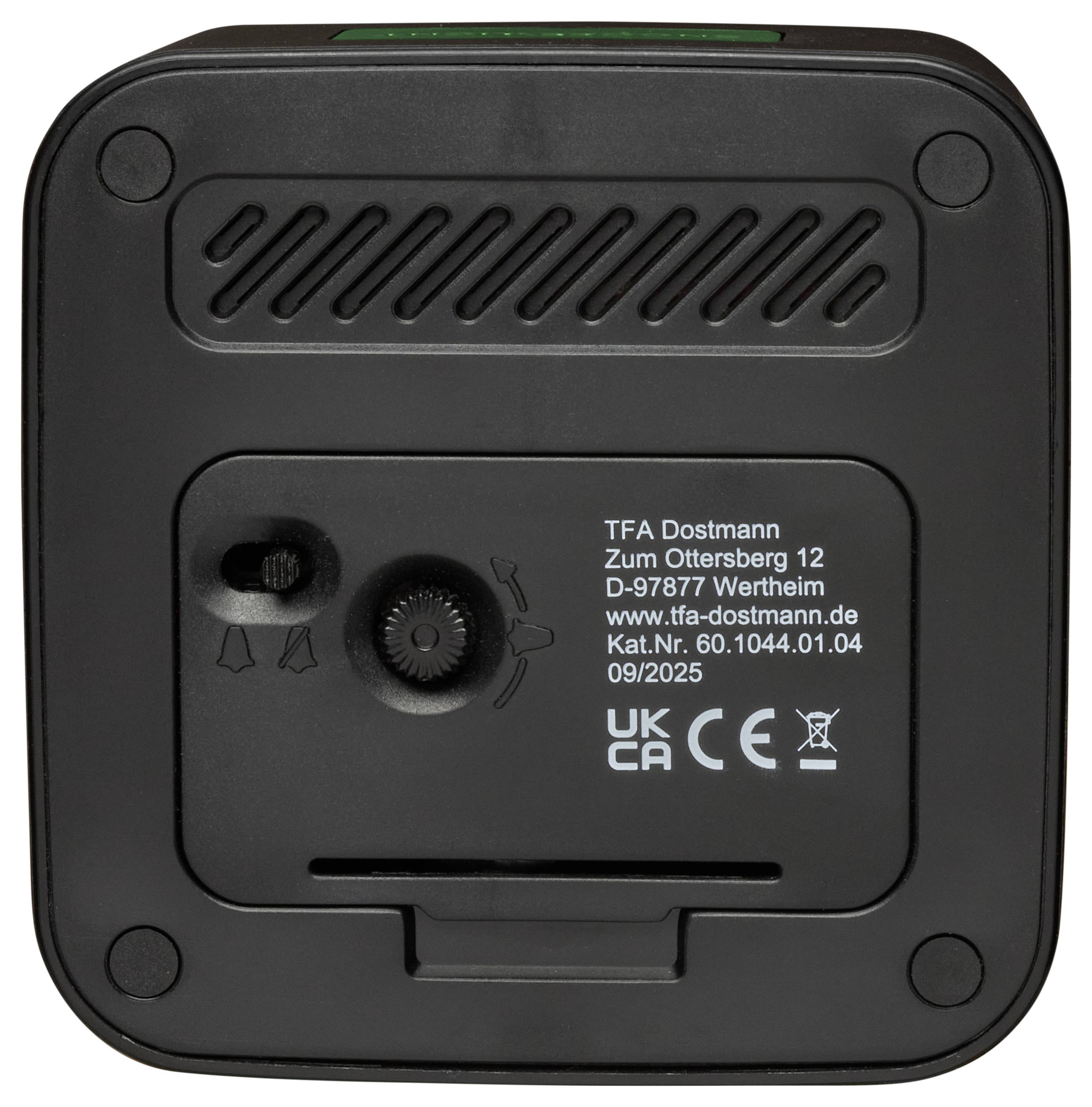 Egy fekete TFA Dostmann ébresztőóra hátsó nézete az akkumulátor-rekesszel, állvány-vezérlőelemekkel és termék-címkével.