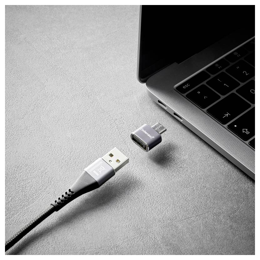 Egy laptop közelképe, melyen egy leválasztható USB-C adapter lebeg egy USB kábel csatlakozó közelében, ami a csatlakozást vagy a töltést sugallja.