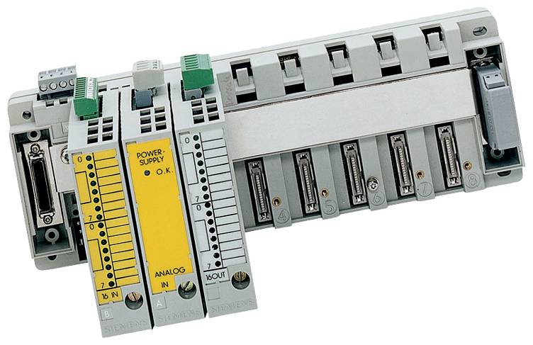 Ipari PLC I/O modul rack több beépíthető modullal, beleértve a sárga tápegységet és az analóg bemeneti modult.