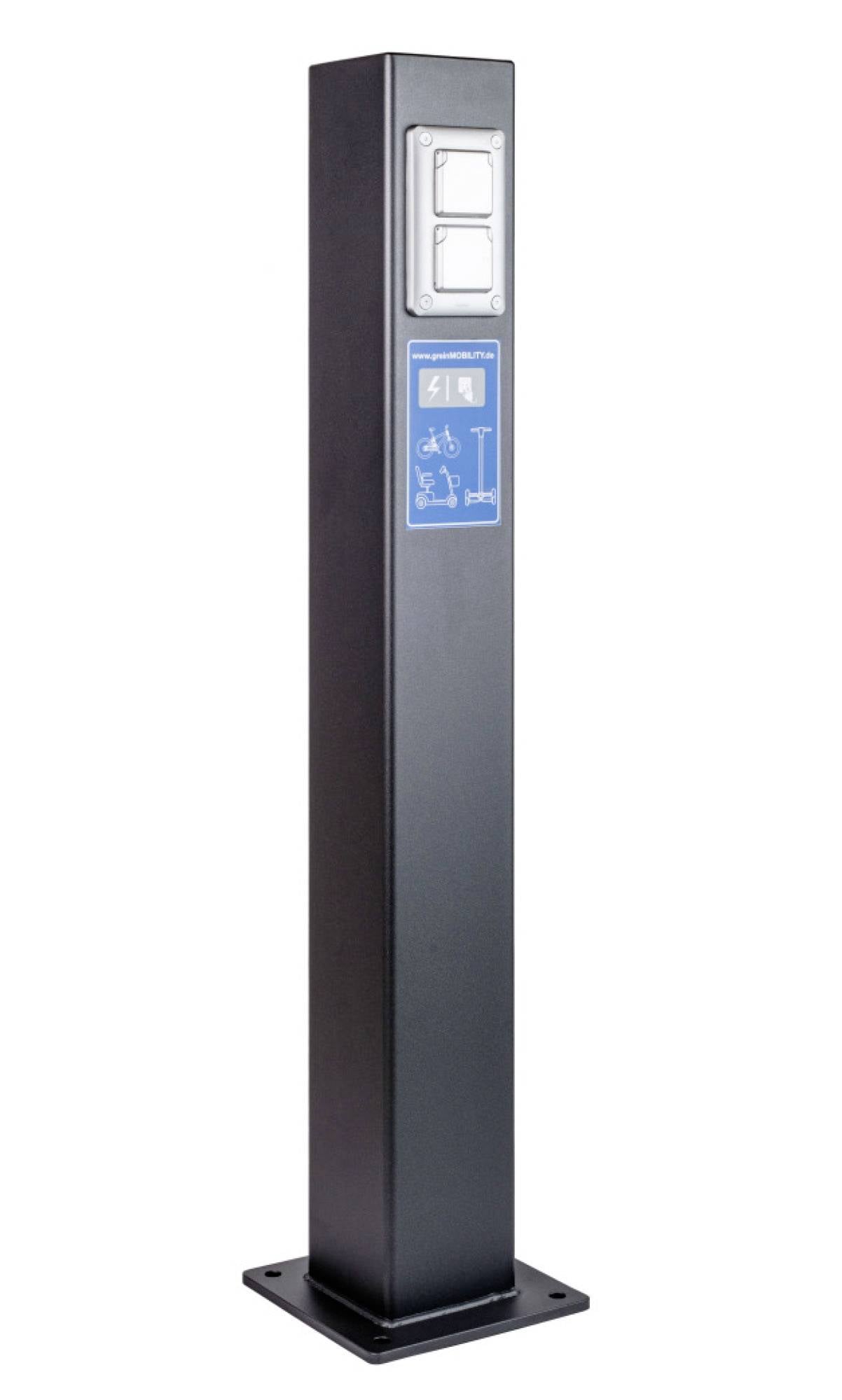 Magas fekete töltőoszlop két elektromos aljzattal és egy kék tábla, amely kerekesszék akadálymentesítésének és kerékpár parkolásának ikonjaival rendelkezik.