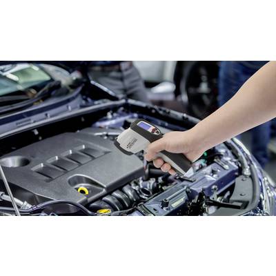 Egy kéz infravörös hőmérőt tart egy autó nyitott motorháztető fölött, hogy lemérje a hőmérsékletet.