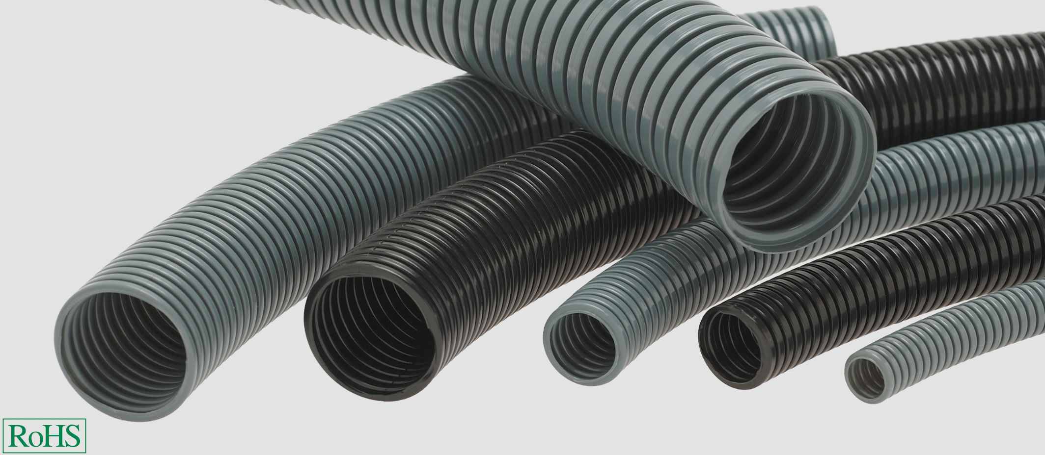 Több rugalmas, fekete-szürke műanyag tömlő, amelyek különböző irányokba mutatnak. Egy 'RoHS'-logó látható.