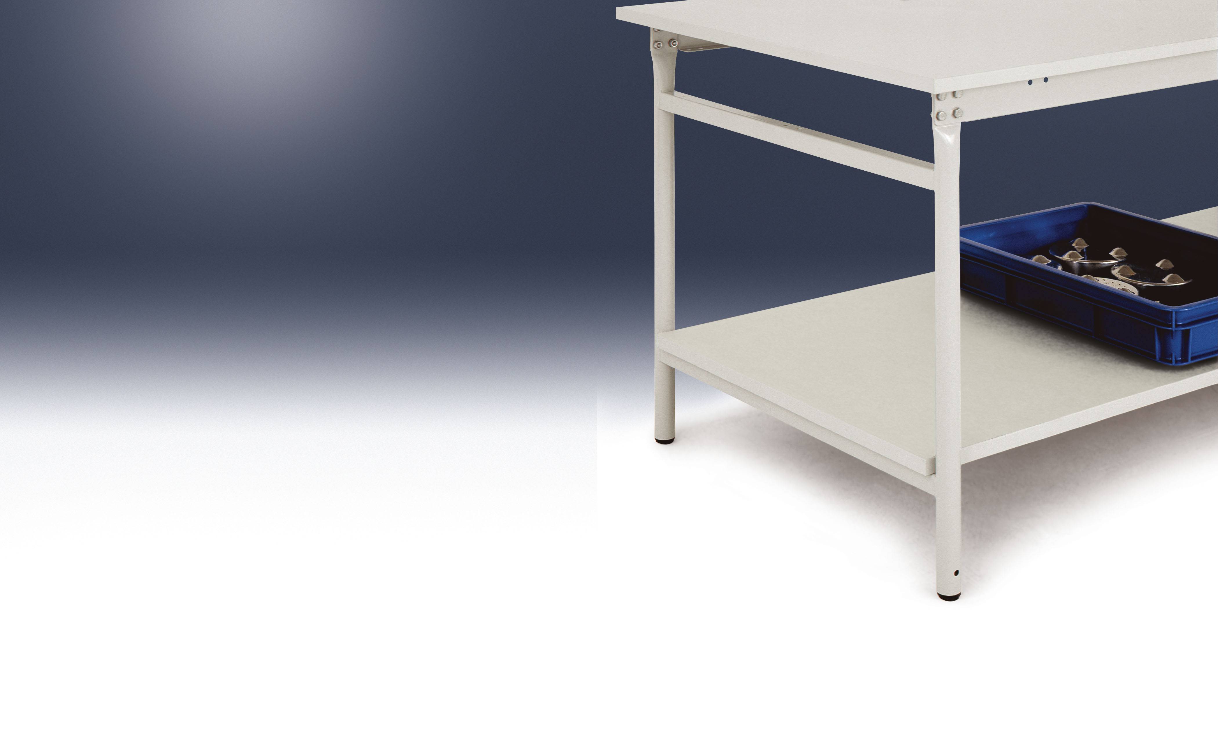 Egy fehér asztal egy kék dobozzal az alsó polcán. A doboz kis fémtárgyakat tartalmaz. Sötét háttér.