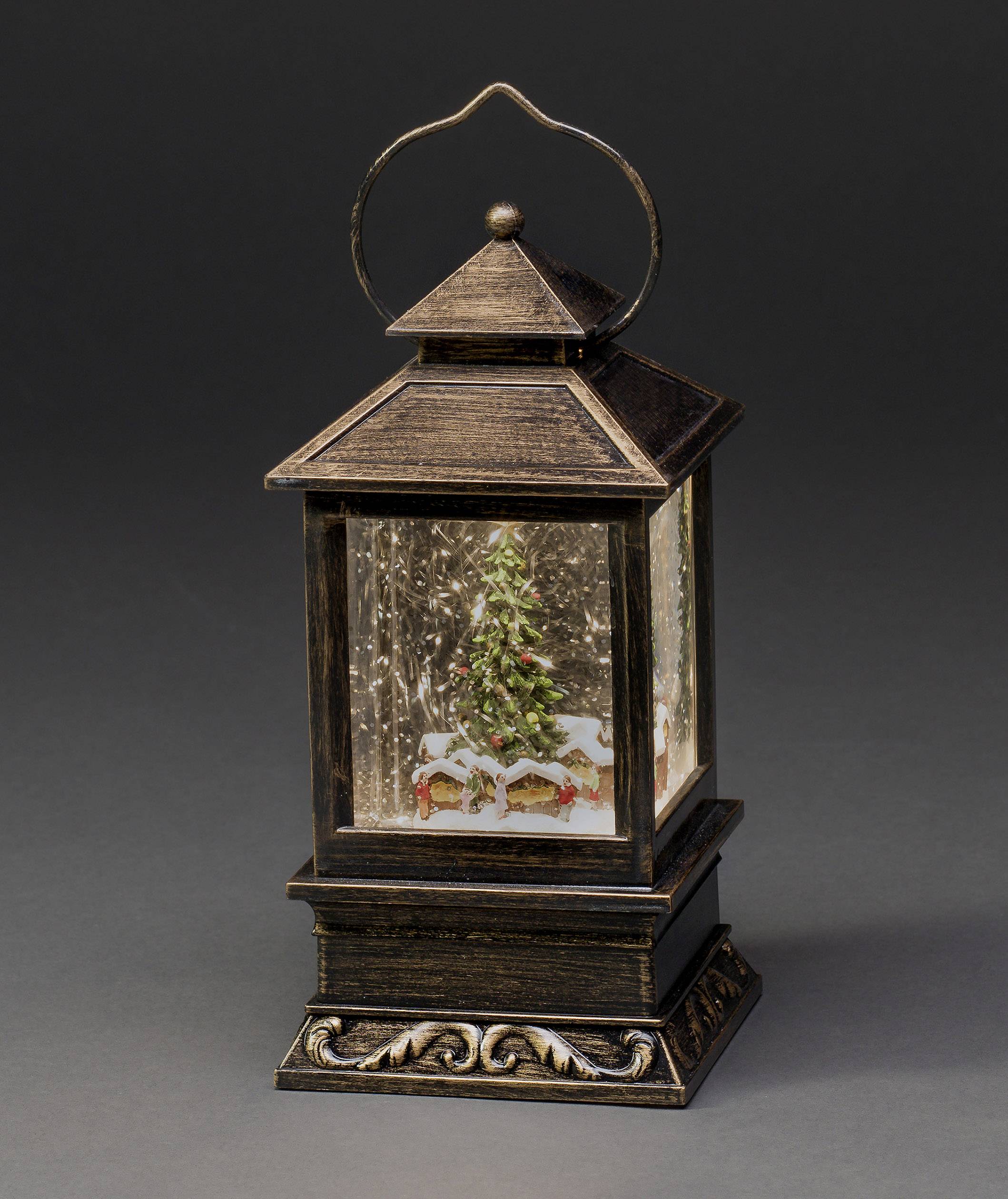 Karácsonyfás lámpás téli hangulatban, havas tájjal a belsejében, körülvéve hóeséssel. Dekoratív jelenet ünnepi hangulatban.