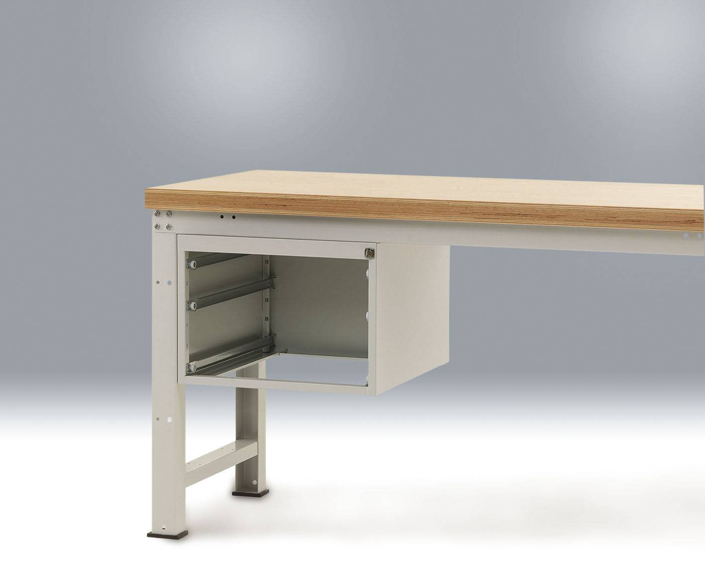 Fa asztallap fémlábakon, az egyik lábába épített nyitott fémfiókkal. Egyszerű, modern dizájn, szürke háttér előtt.