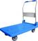 Kék, négy kerekű platformkocsi, összecsukható fogantyúval, alkalmas nehéz tárgyak szállítására raktárban vagy üzemben.