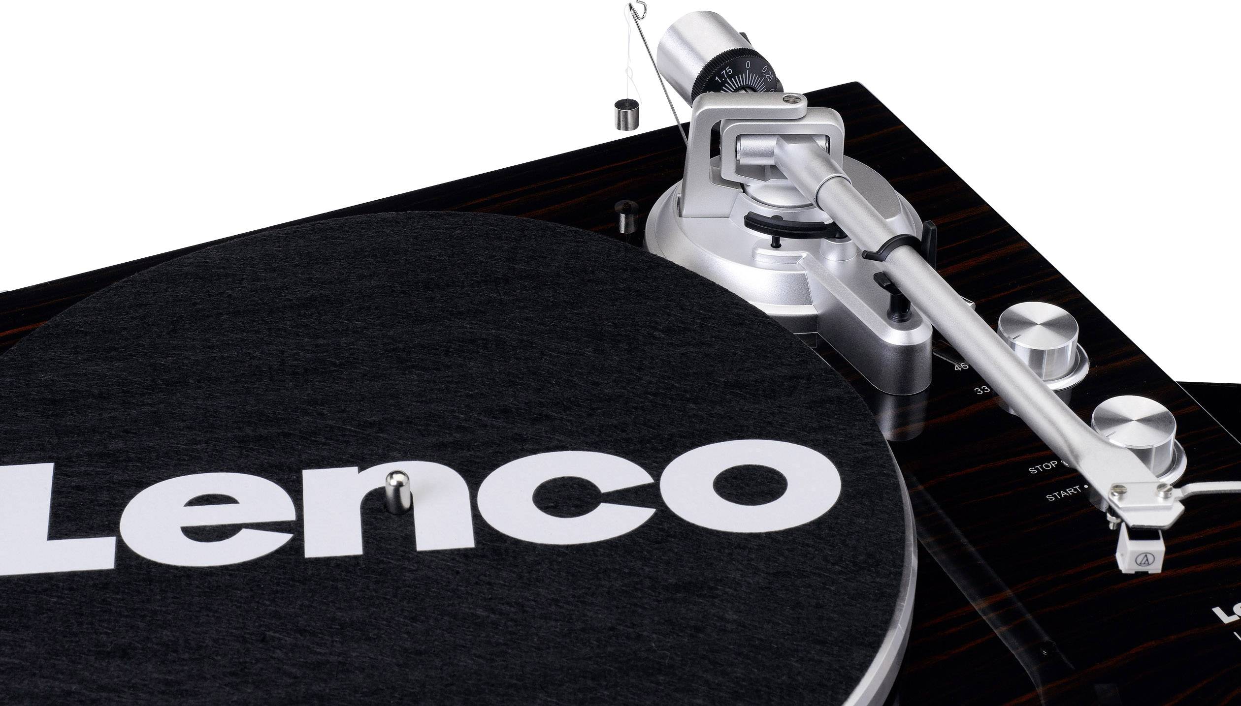 Közeli felvétel egy lemezjátszóról, amelynek fedőlapján a 'Lenco' felirat olvasható. A hangkar a jobb oldalon látható.