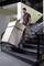 Egy férfi egy nagy dobozt szállít lefelé egy lépcsőn egy lépcsőjáró kocsival.