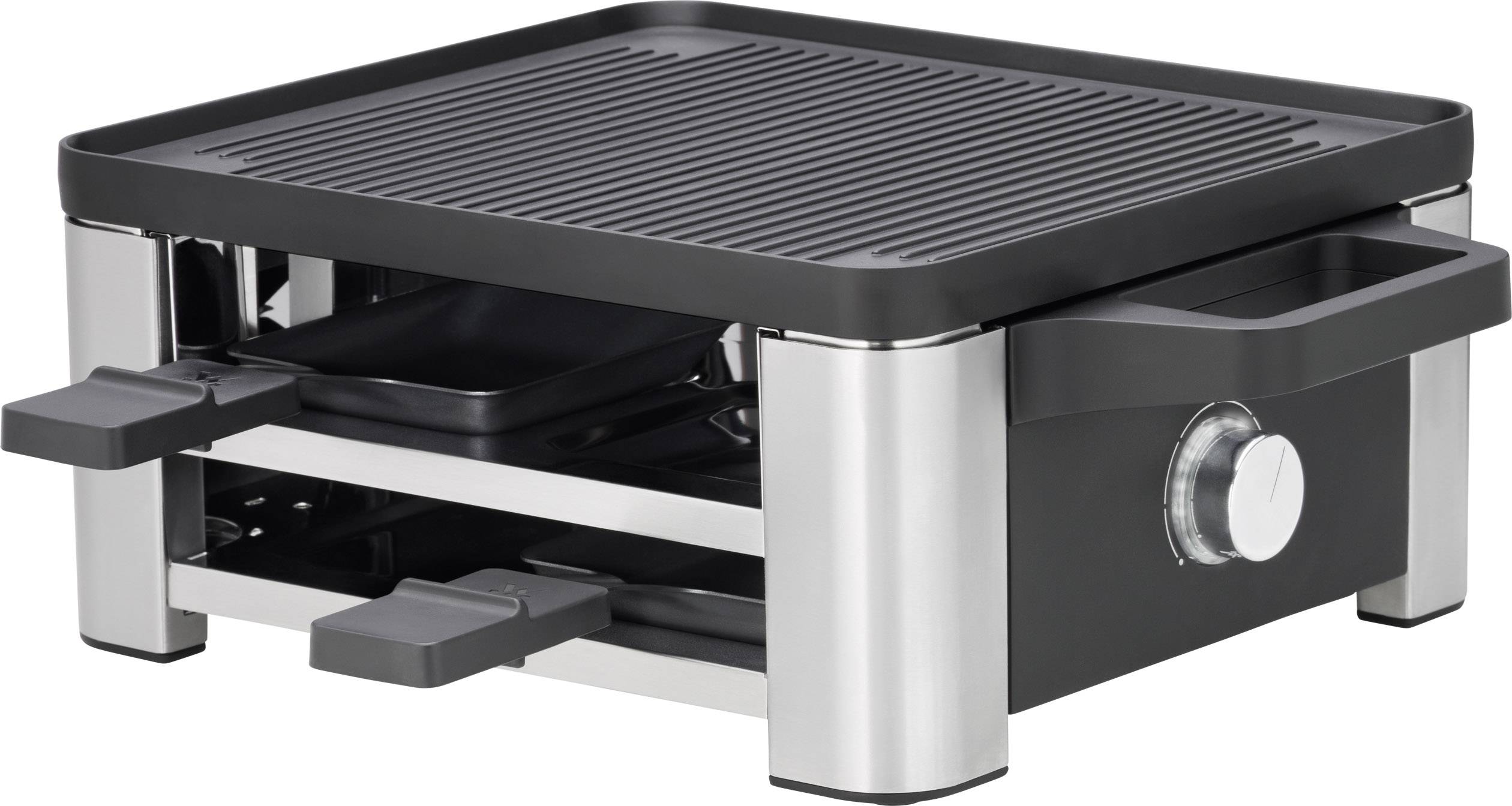 Egy fekete rozsdamentes acél raclette-grill több kis serpenyővel és sima grillfelülettel. Alkalmas közös asztali főzéshez.