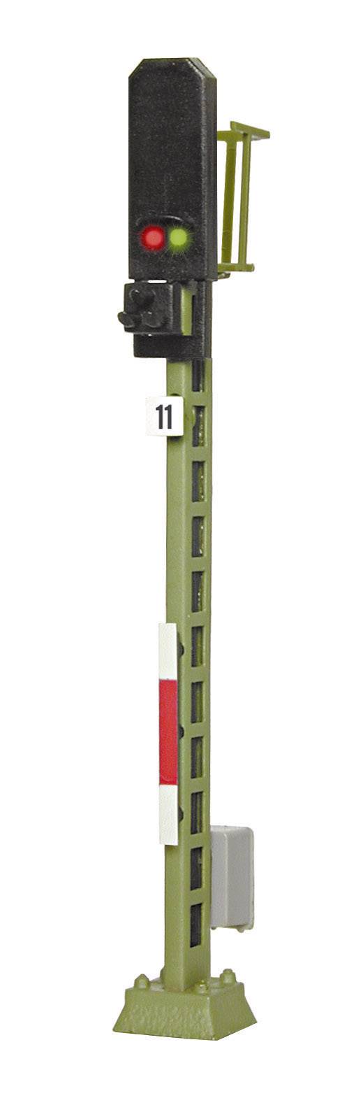 Vasúti jelzőlámpa magas oszlopon világító piros és zöld fénnyel, valószínűleg a vasúti forgalom irányítására szolgálva.