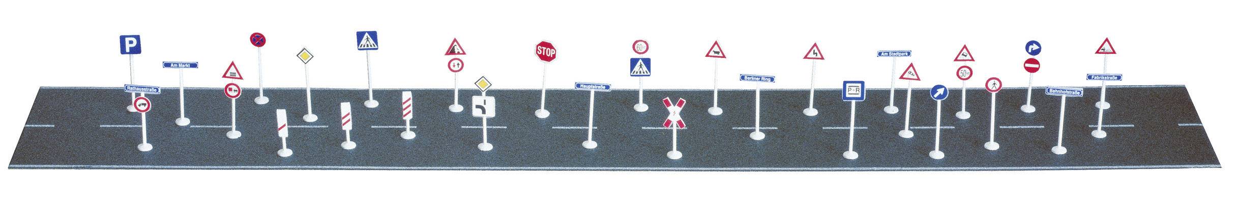 Különböző közlekedési táblák egy modellúton, köztük parkolási tilalom, elsőbbségadás és gyalogátkelőhely jelzőtáblái.