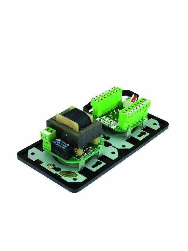 Egy zöld elektromos áramköri modul fekete alkatrészekkel, egy fekete alapra szerelve.
