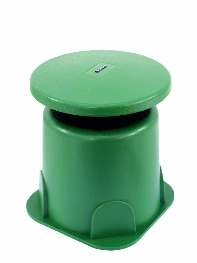 Zöld műanyag fedél hengeres tárolón, valószínűleg egy szelepakna fedele, kis téglalap alakú nyílással.