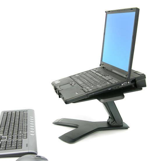 Két laptop, az egyik állványon és nyitva, a másik zárt helyzetben az előtérben. A nyitott laptop képernyője kék.