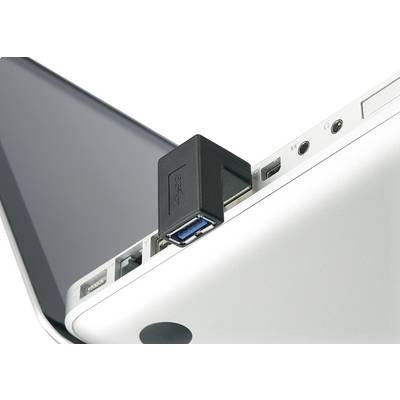 Egy fekete USB-dugasz van bedugva egy ezüstszínű laptop USB-portjába. A laptop félig nyitva van.
