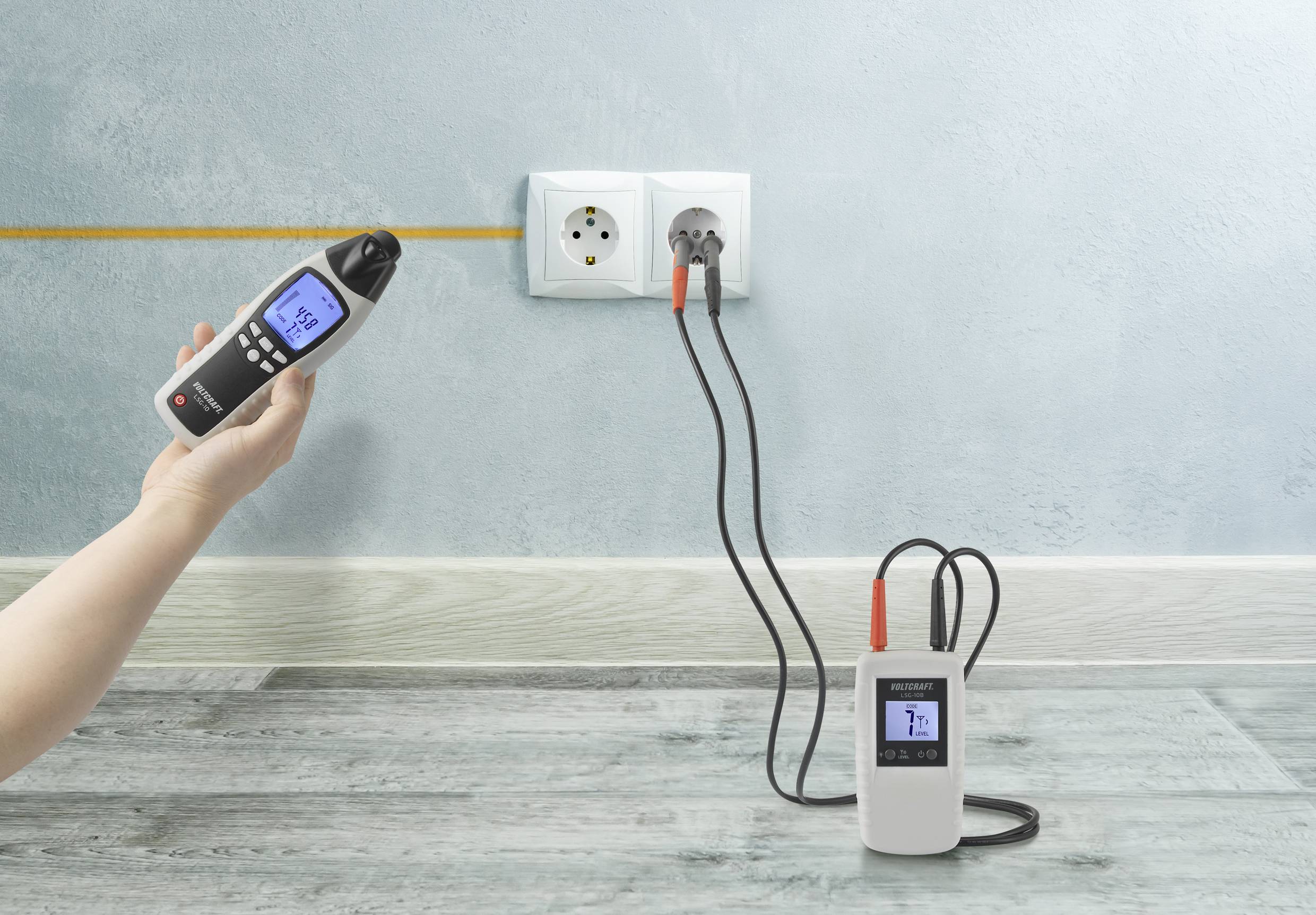 Una persona sta utilizzando uno strumento digitale per verificare l'efficienza energetica di una presa elettrica. Un altro dispositivo effettua misurazioni in parallelo.
