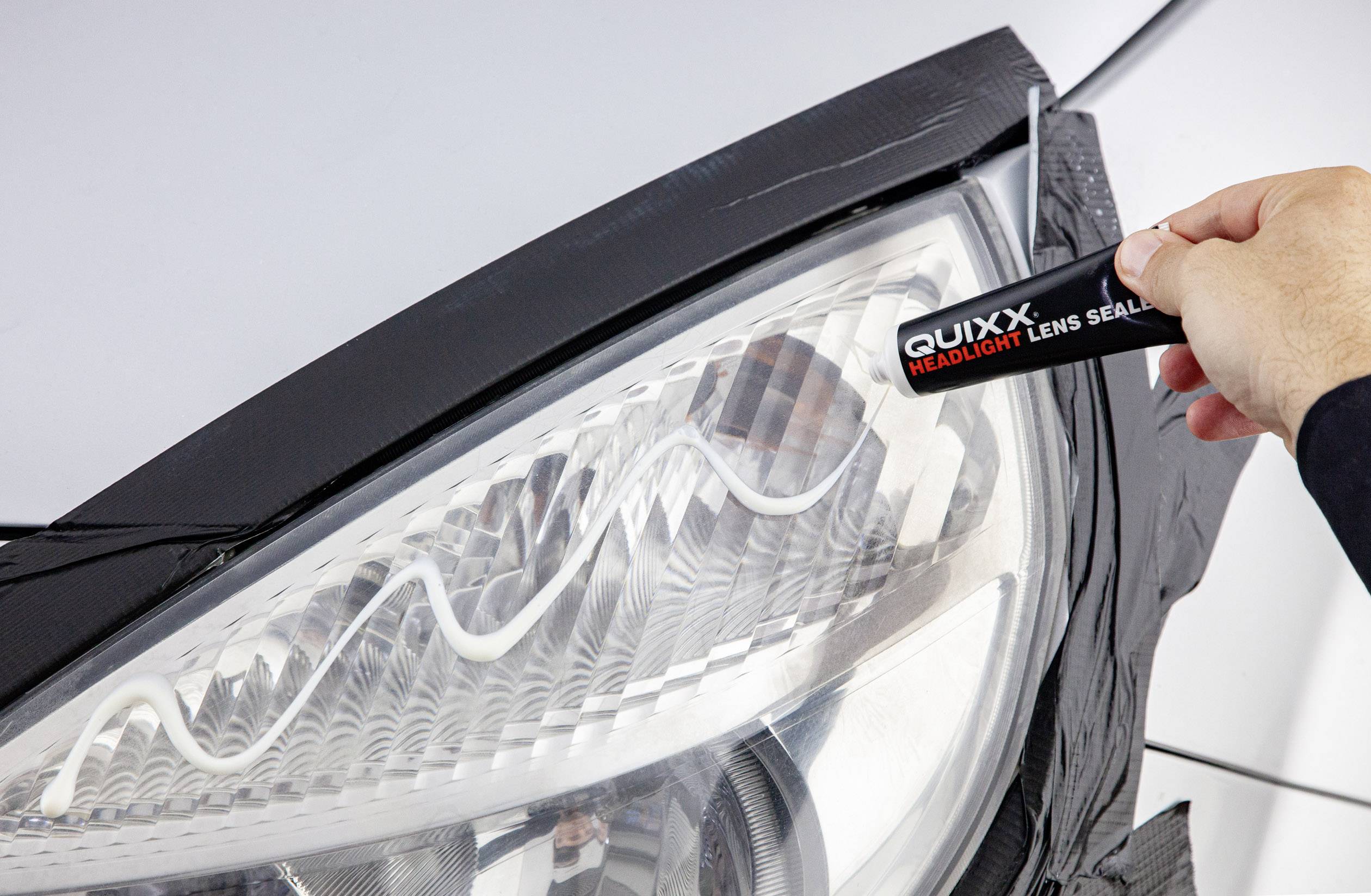 Una persona applica 'QUIXX Headlight Lens Sealer' su un faro per sigillare la superficie.