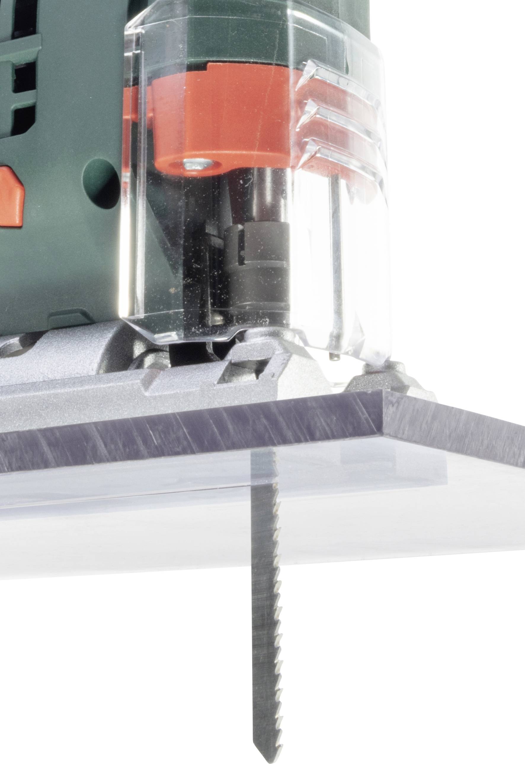 Un seghetto alternativo taglia attraverso una lastra di plastica trasparente. Il processo di taglio è visibile in dettaglio dal lato.