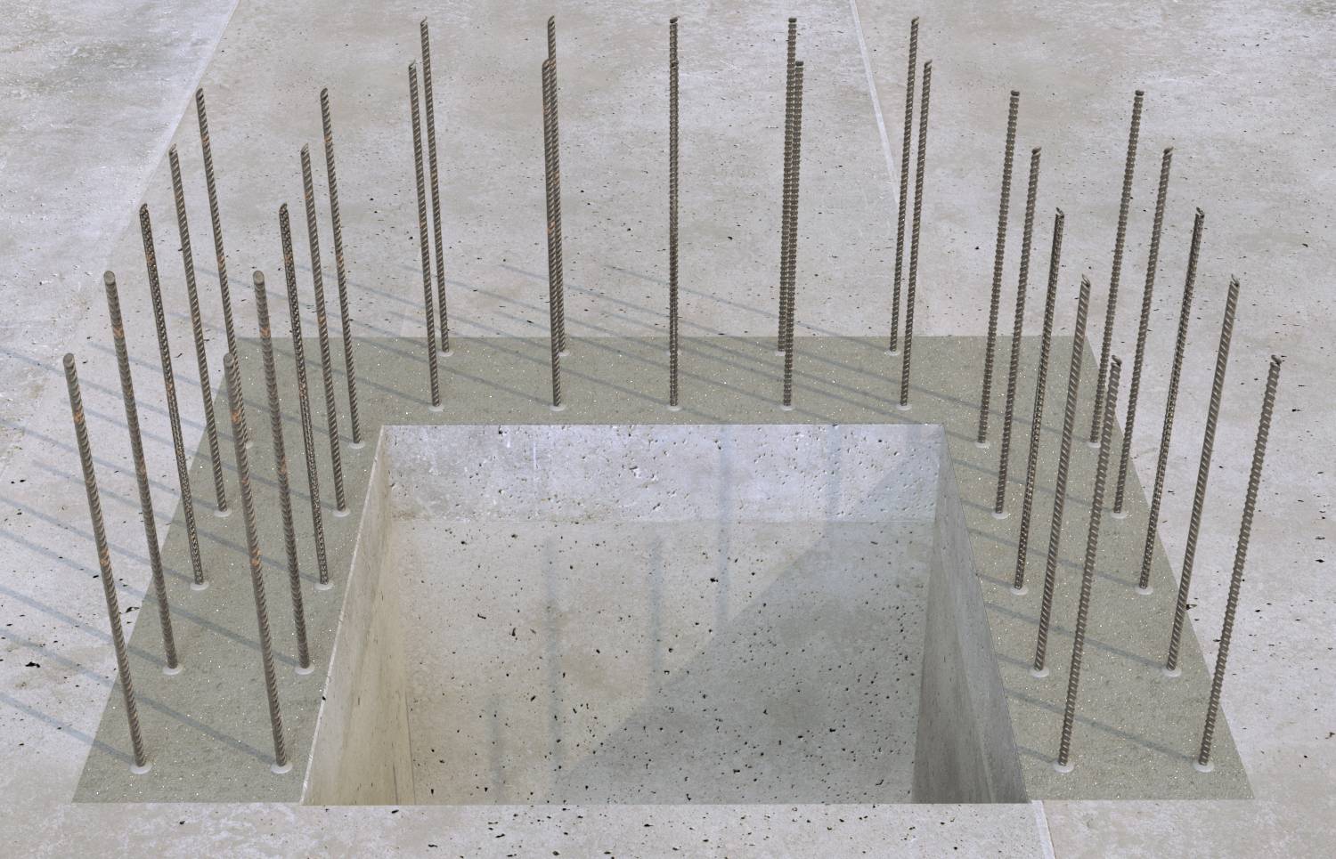 Fondazione in calcestruzzo con un'apertura quadrata incassata, circondata da barre d'acciaio verticali equidistanziate per il rinforzo strutturale della costruzione.