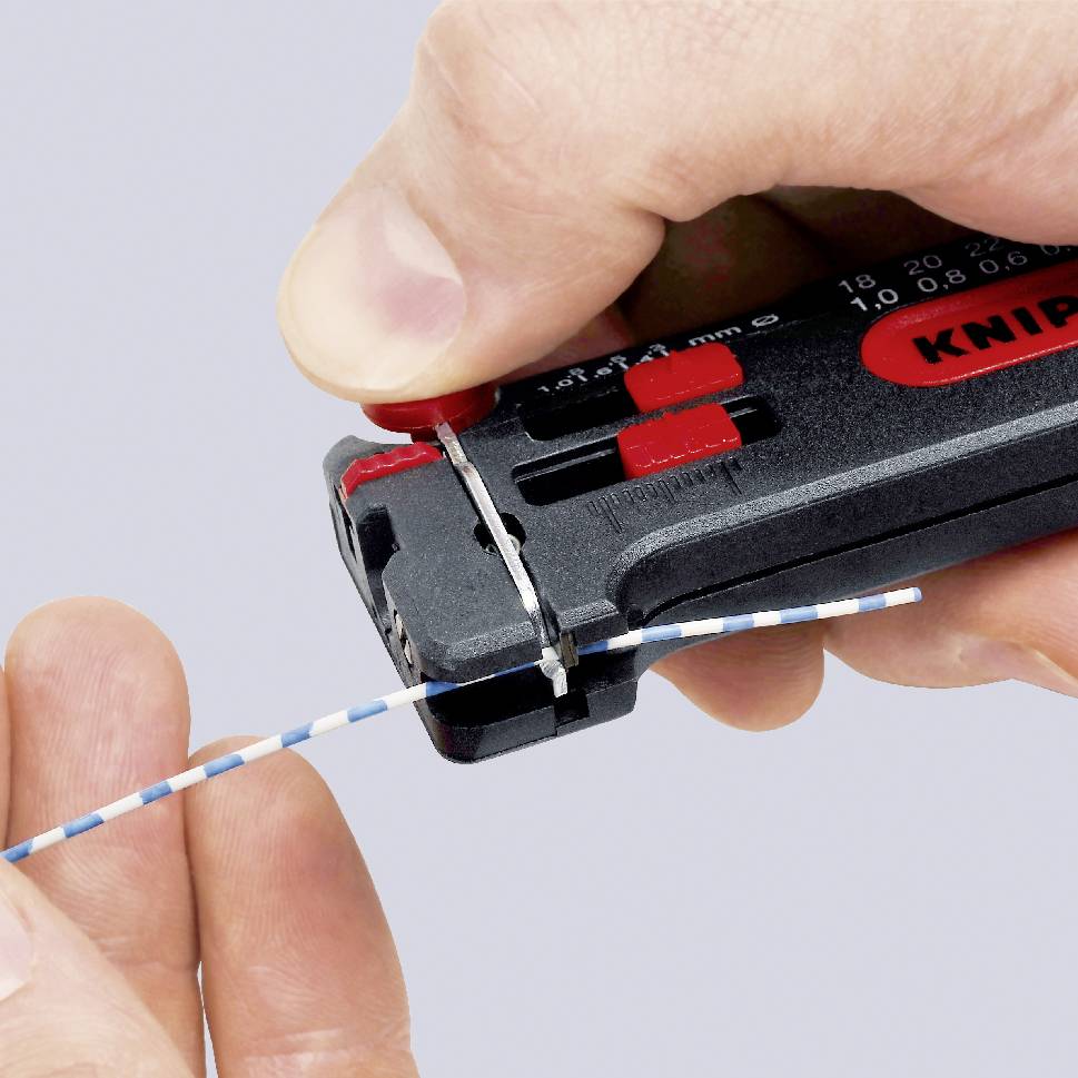 Una mano sta utilizzando un utensile per spellare per rimuovere l'isolamento da un cavo blu con strisce bianche.